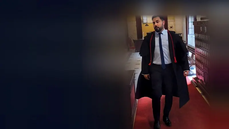 A mesma foto do advogado no corredor do Tribunal, inteira à direita, com as bordas da própria foto continuadas e escurecidas à esquerda, para o topo do computador